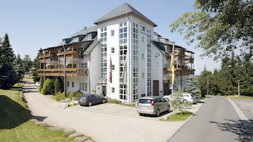 Ein mehrstöckiges Hotel mit modernem Design, das Balkone und große Fenster bietet.