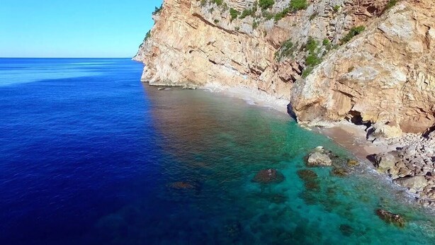 A coastal landscape with clear blue waters, rocky cliffs, and a sandy beach. - Garden Oasis Pool Villa (Konavle)