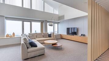 A modern living room with a sofa, coffee table, and TV.