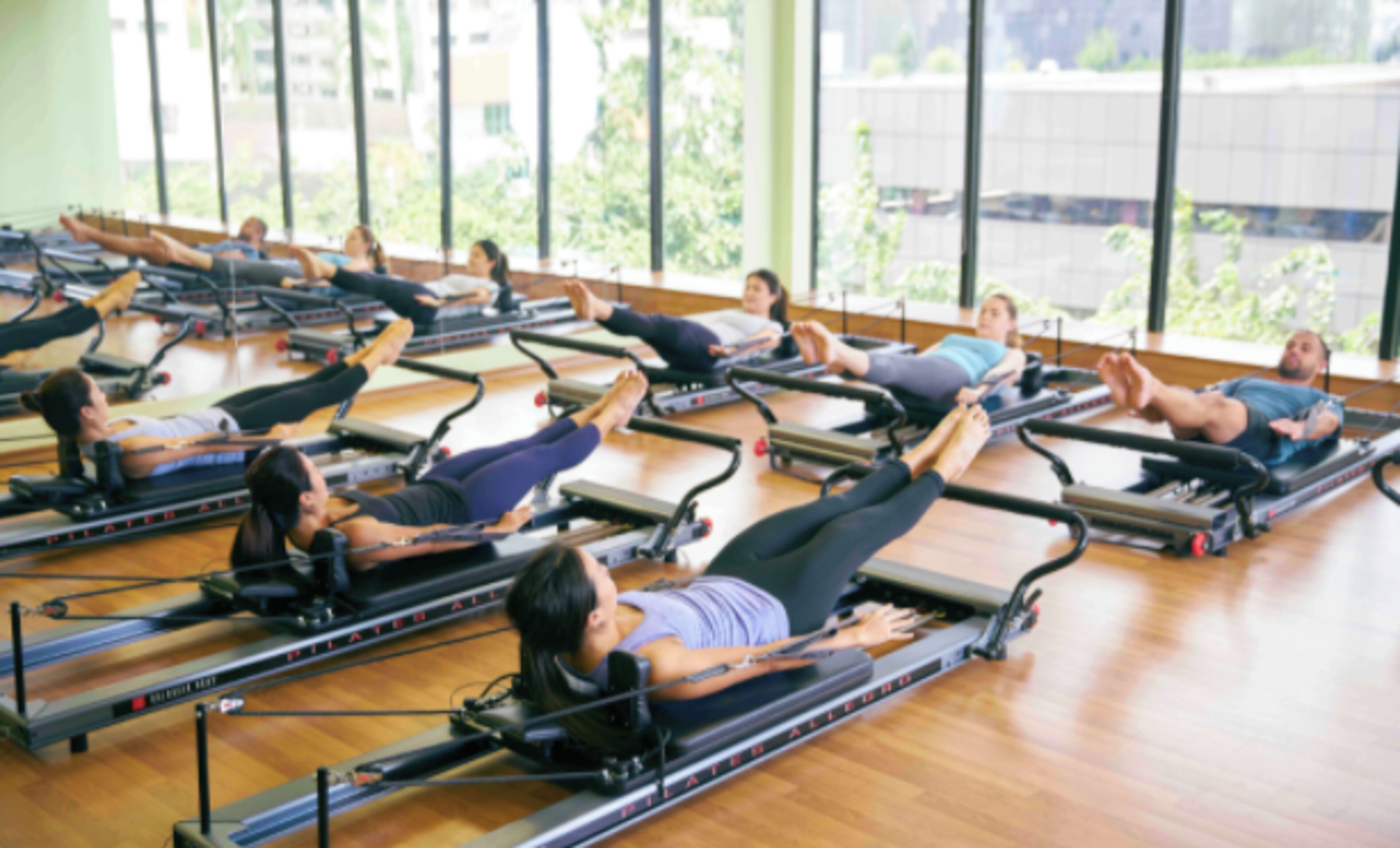 Pilates-studio, jossa on useita reformer-laitteita rivissä.