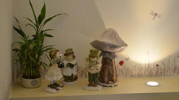 A shelf with figurines, a potted plant, and a wall mural.