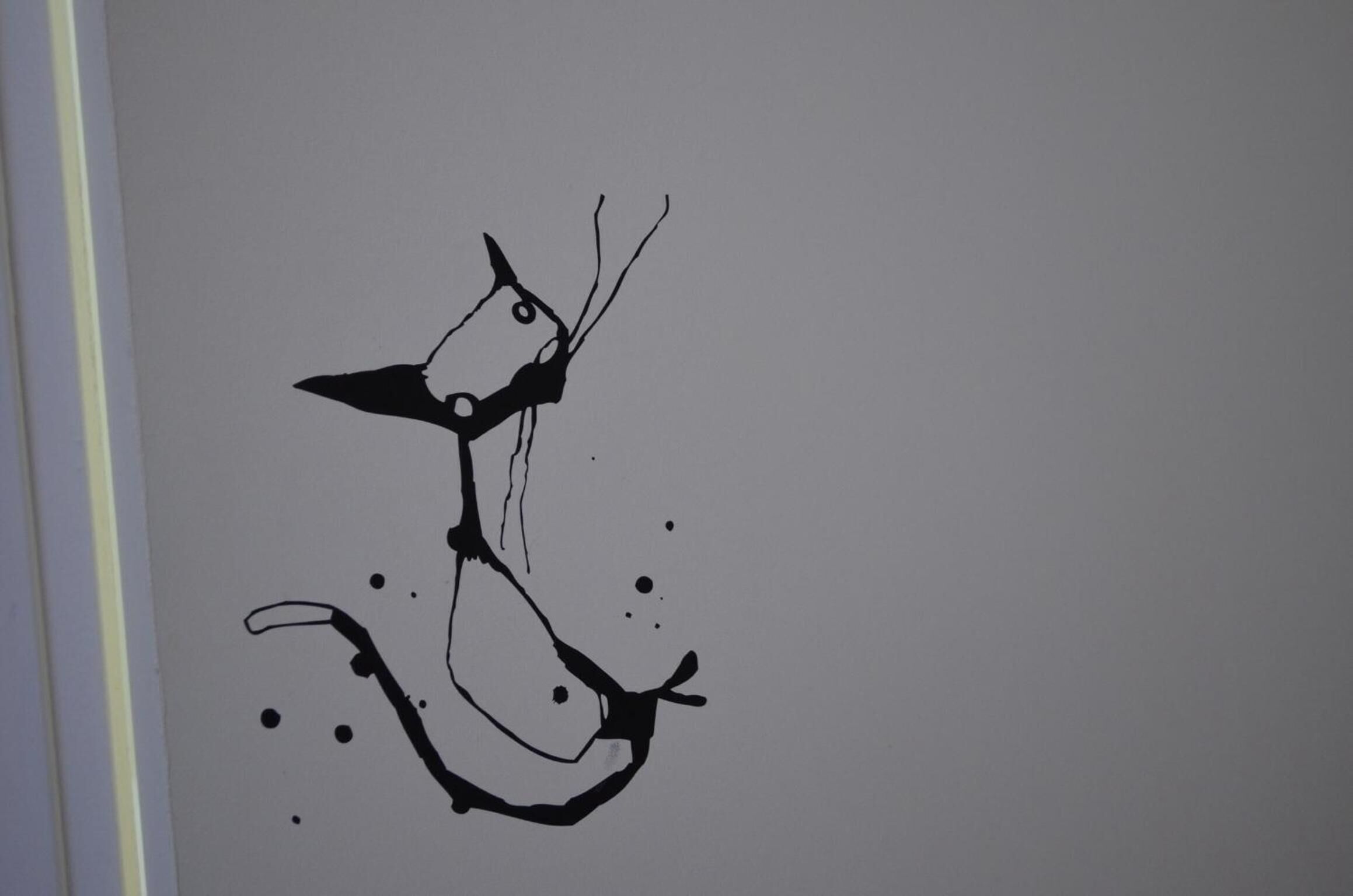 Un simple dessin au trait noir représentant un poisson sur un fond uni.