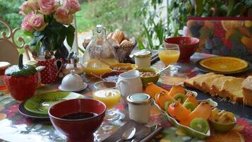Une table de petit-déjeuner avec divers aliments, notamment du pain, des fruits et des boissons.
