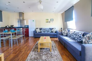 Ein modernes Wohnzimmer mit Sofa, Couchtisch und Essbereich.