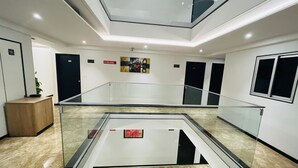 Un interior moderno con un atrio de vidrio, un letrero de 'No Fumar' y un diseño minimalista.