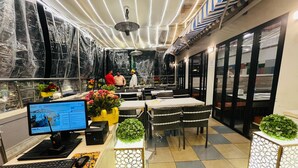 Un espacio de oficina moderno con un escritorio, sillas y plantas decorativas.
