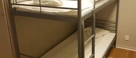 A bunk bed with metal railings and a white mattress.