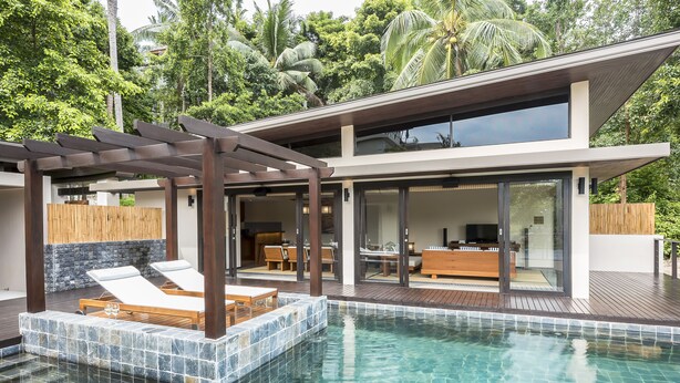 A modern house with a swimming pool, wooden deck, and a patio area with lounge chairs. - Aspire Villas Koh Phangan (Ko Pha-ngan)