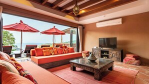 Un salon moderne avec un canapé, une table basse et deux parasols rouges.