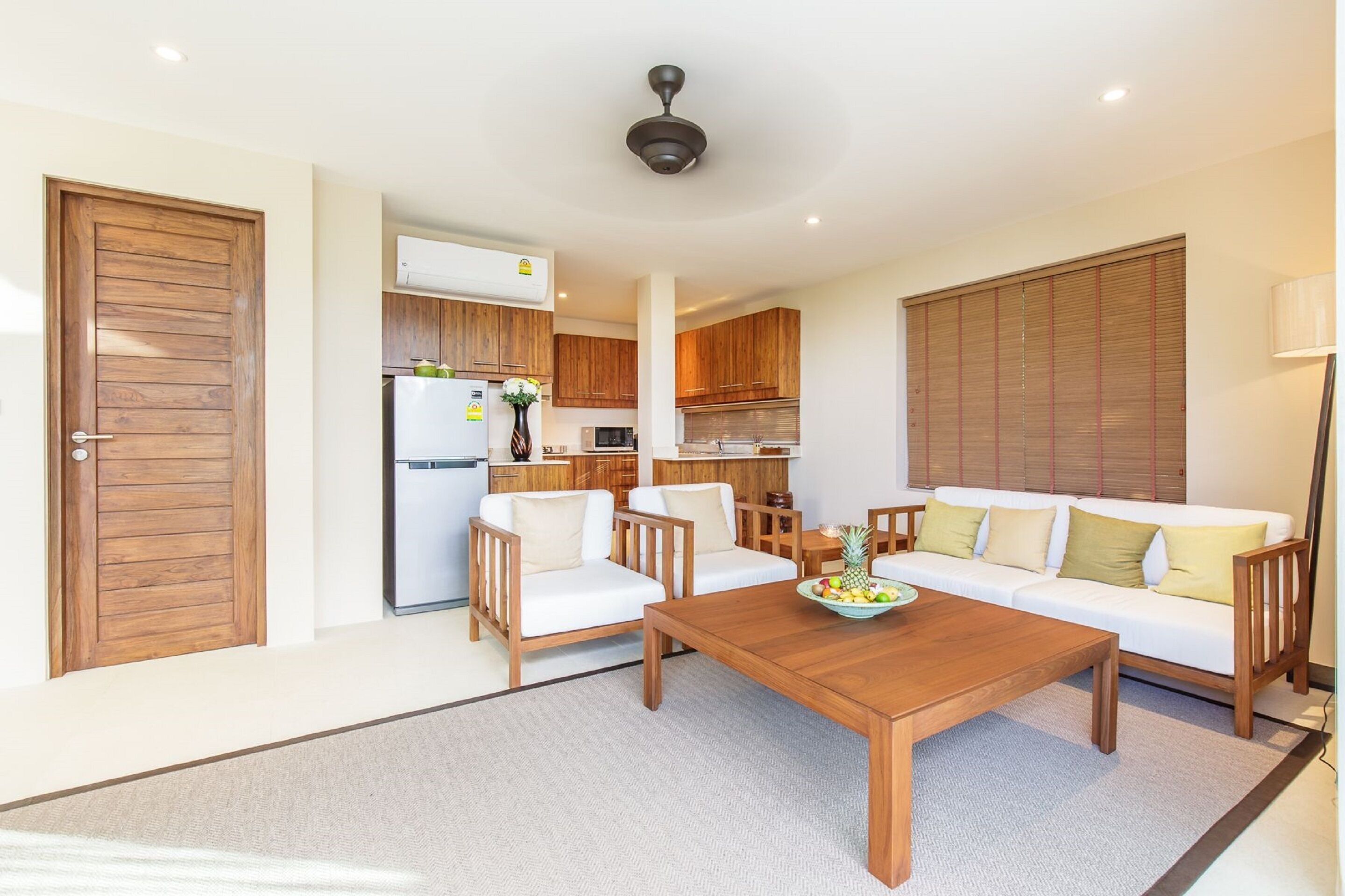 A modern living room with a wooden coffee table, white sofa, and matching chairs.