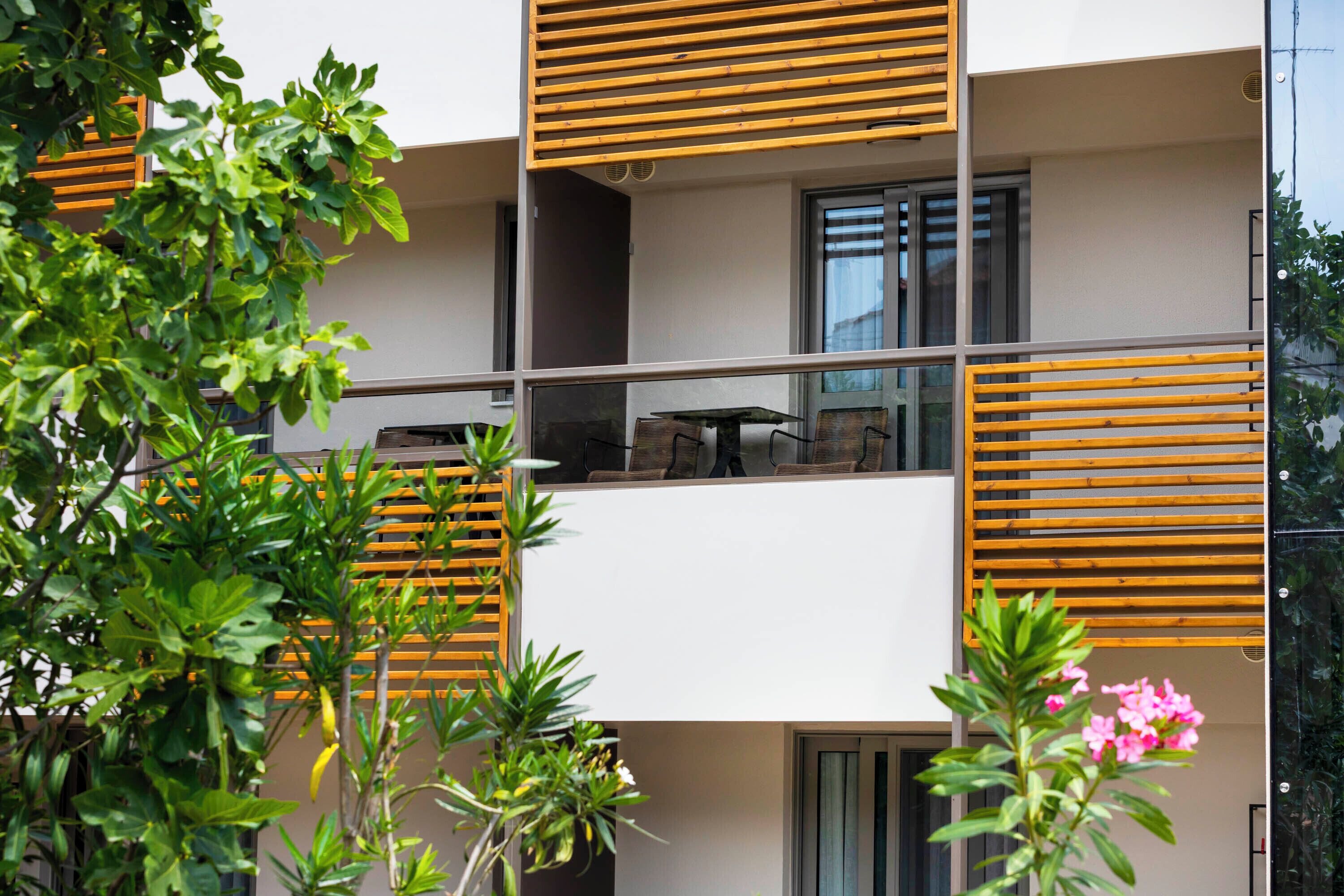 Un apartamento moderno con balcón, ventanas amplias y vistas al entorno verde.