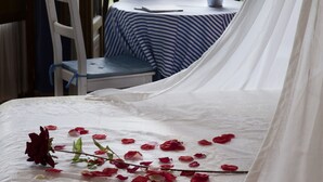 A room with a bed, a table with a striped tablecloth, and a view of a landscape. - Hotel Rural La Llosa de Fombona (Gozon)