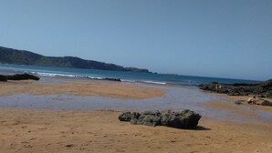 A beach with rocky outcrops and calm waters. - Hotel Rural La Llosa de Fombona (Gozon)