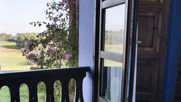 Enjoy a serene view of the lush landscape from this room, which offers access to an outdoor area through a door with a glass panel.
