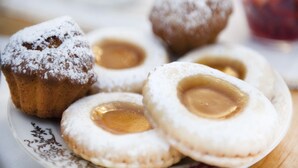 A plate of pastries with powdered sugar and a visible filling. - A Due Passi (Forte dei Marmi)