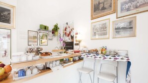 Una barra de desayuno con diferentes alimentos, una máquina de café y cuadros en la pared.