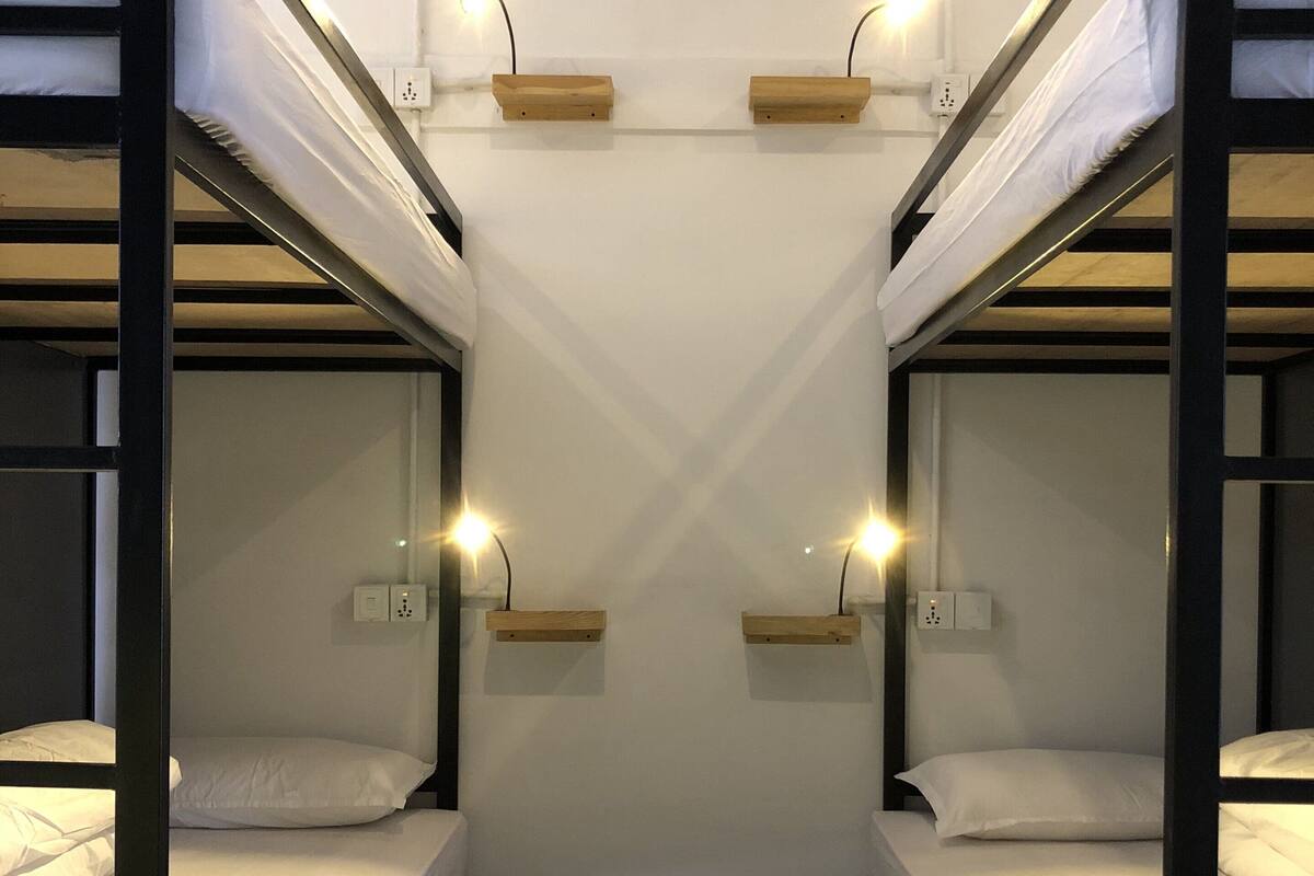 A bunk bed room with two beds, each with a wooden shelf above.