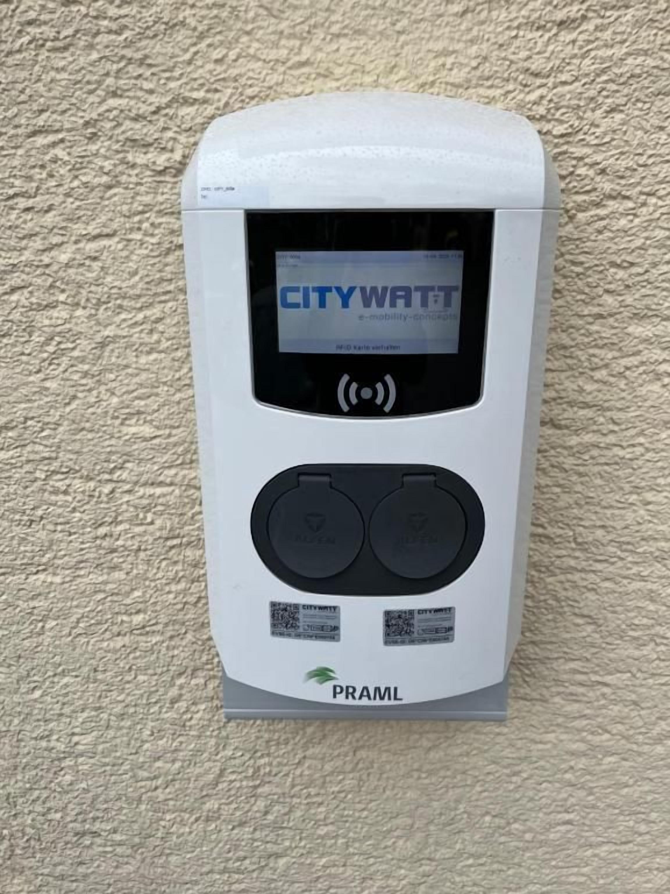 Una estación de carga de movilidad CITYWATCH con pantalla digital, dos puertos de carga y un código QR.