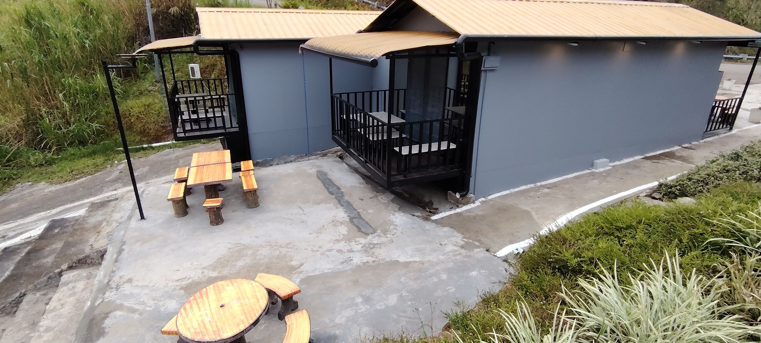 A small building with a balcony and outdoor seating area.