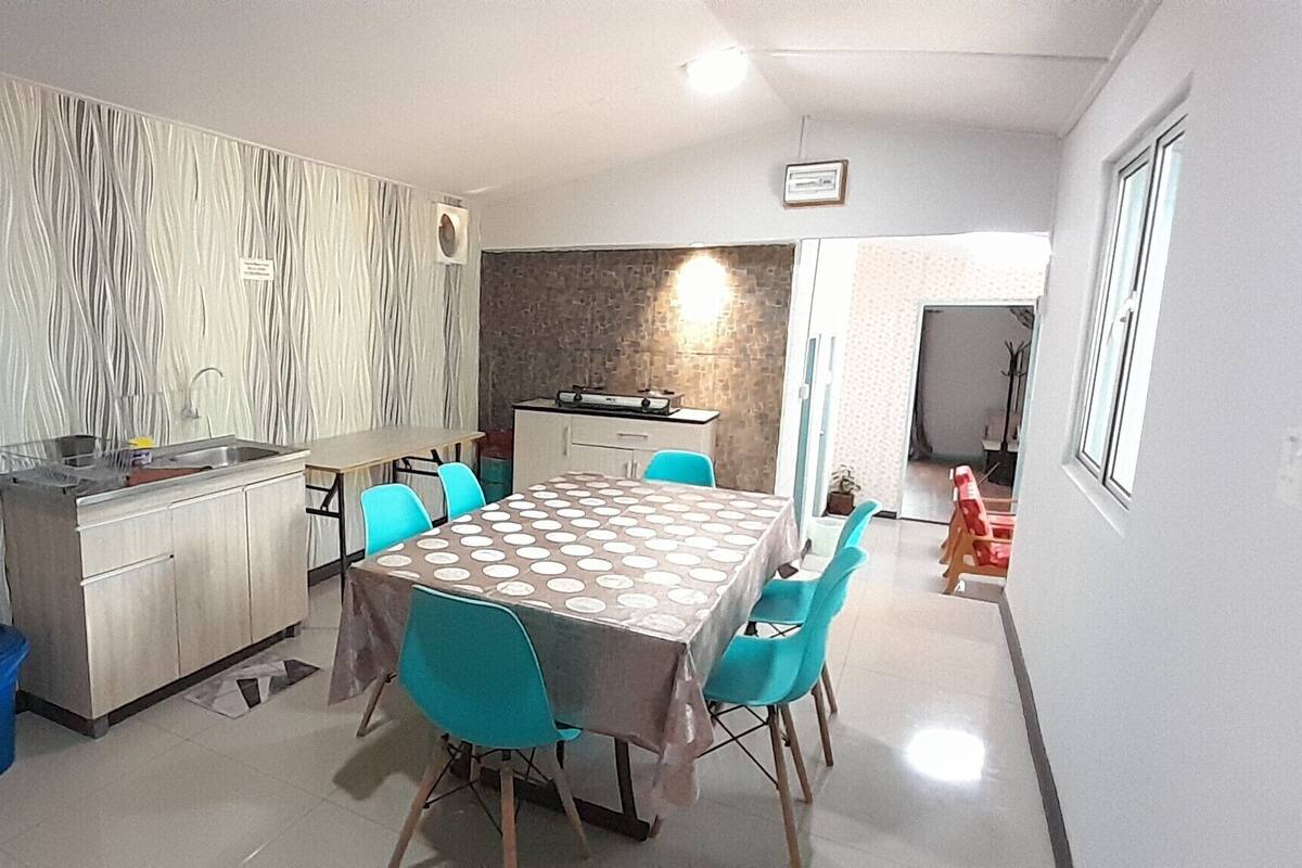 A compact kitchen with a built-in stove, a sink, and a dining area with a table and chairs.