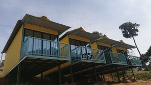 Una hilera de edificios amarillos con barandillas azules y ventanas grandes.