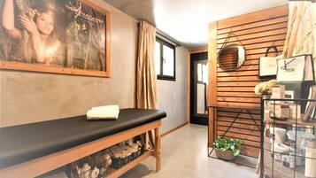 Relax and rejuvenate in our serene spa area, featuring a massage table, comfortable bench, and a selection of spa products.