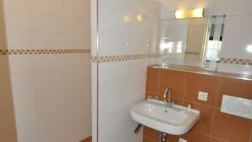 A bathroom with a shower, sink, and toilet.