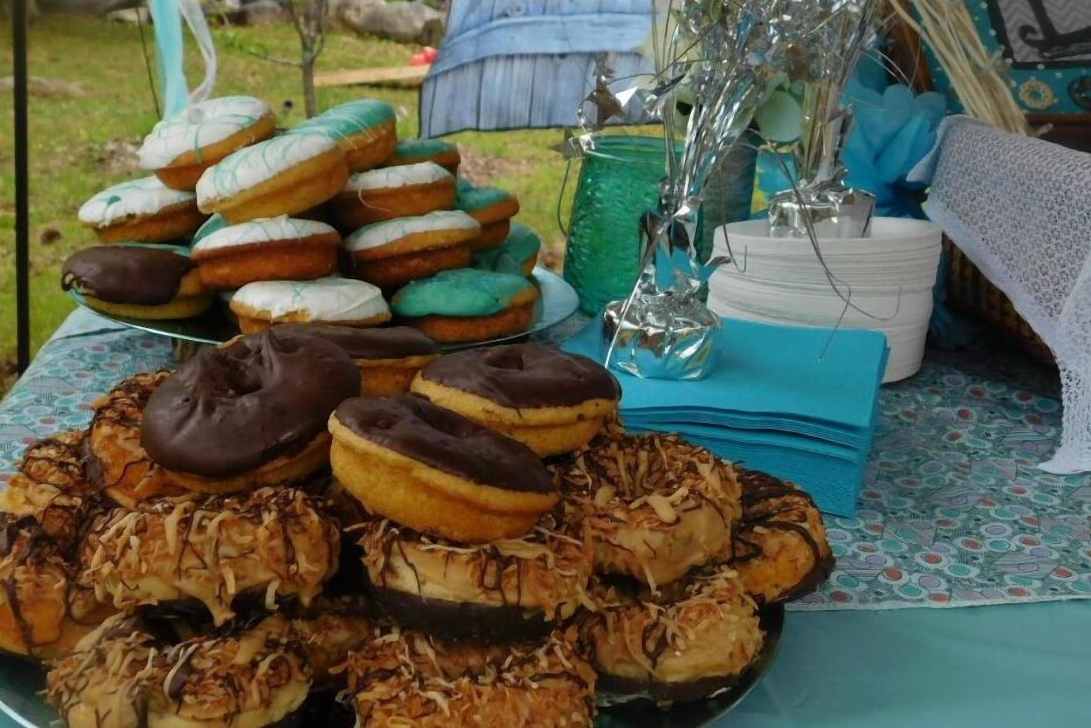 A table with various donuts and a decorative vase.
