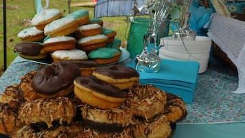 A table with various donuts and a decorative vase.