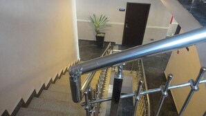 A staircase with metal railings and a potted plant in the background. - Caesar's Court Hotel and Suites (Abeokuta)