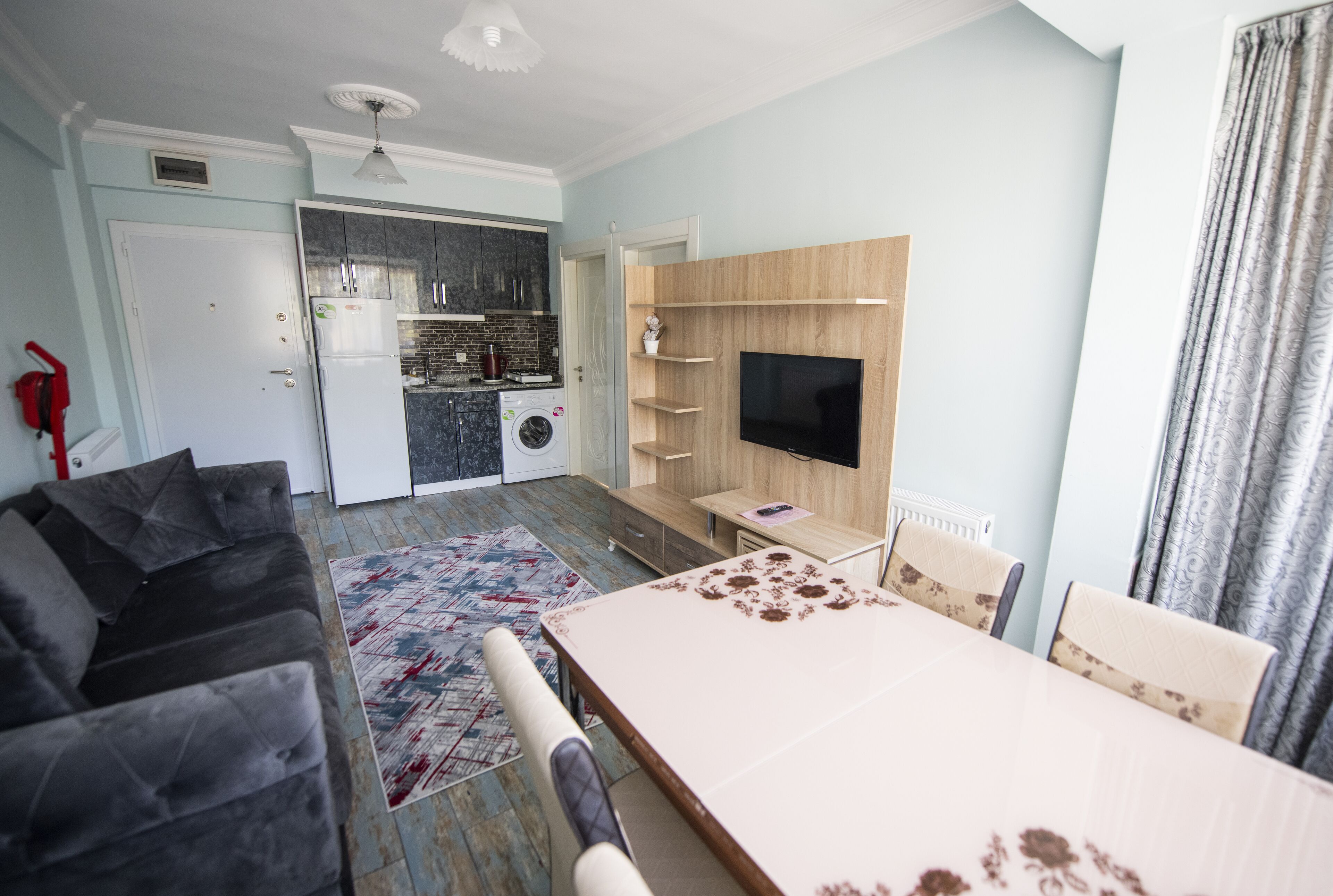 Una sala moderna con un sofá, una mesa de comedor y un televisor.
