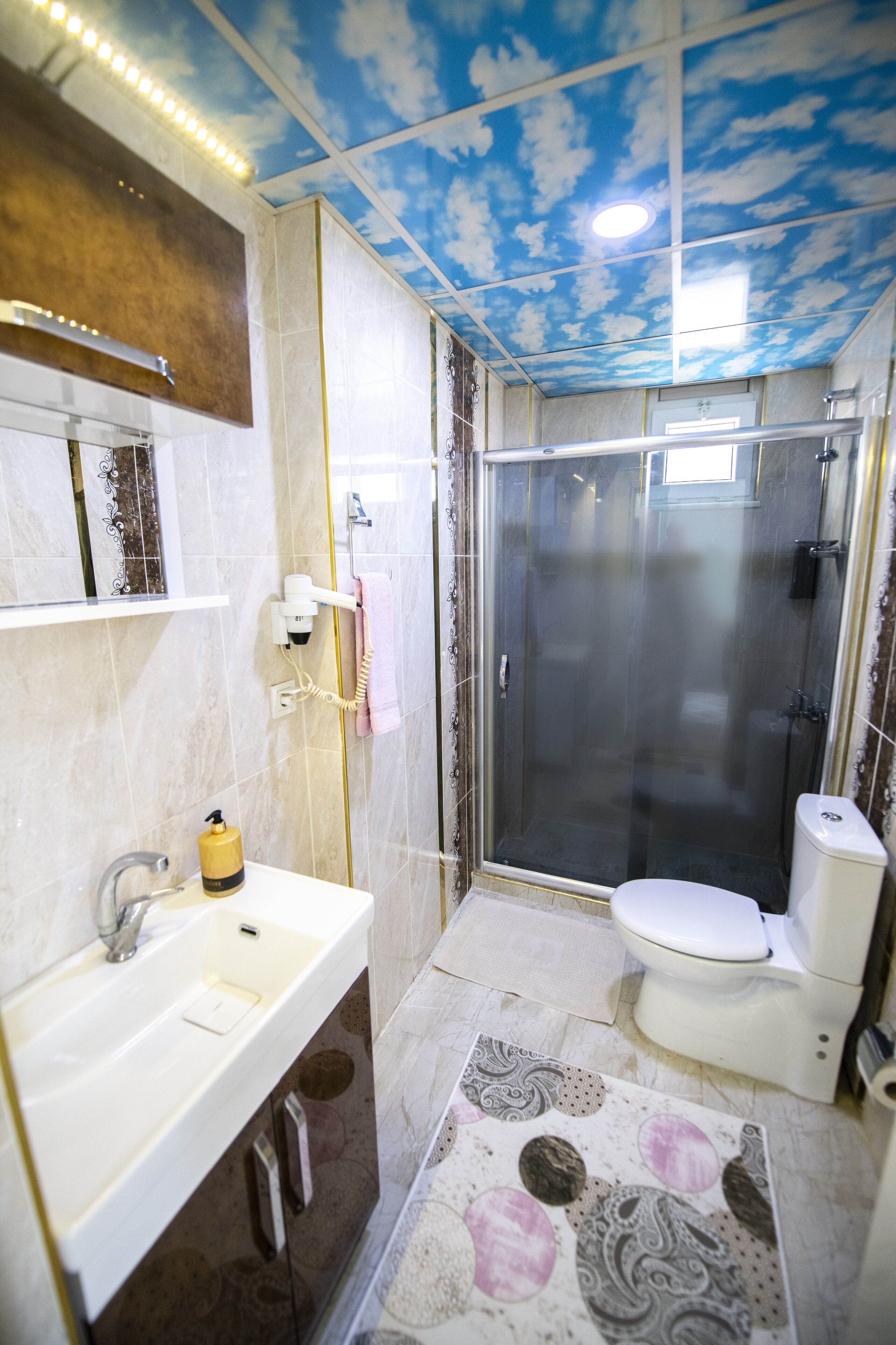 A bathroom with a shower, toilet, and sink.