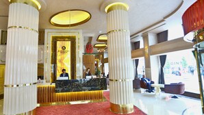 A hotel lobby with a reception desk, large columns, and a red carpet. - Beethoven Premium Hotel (Istanbul)