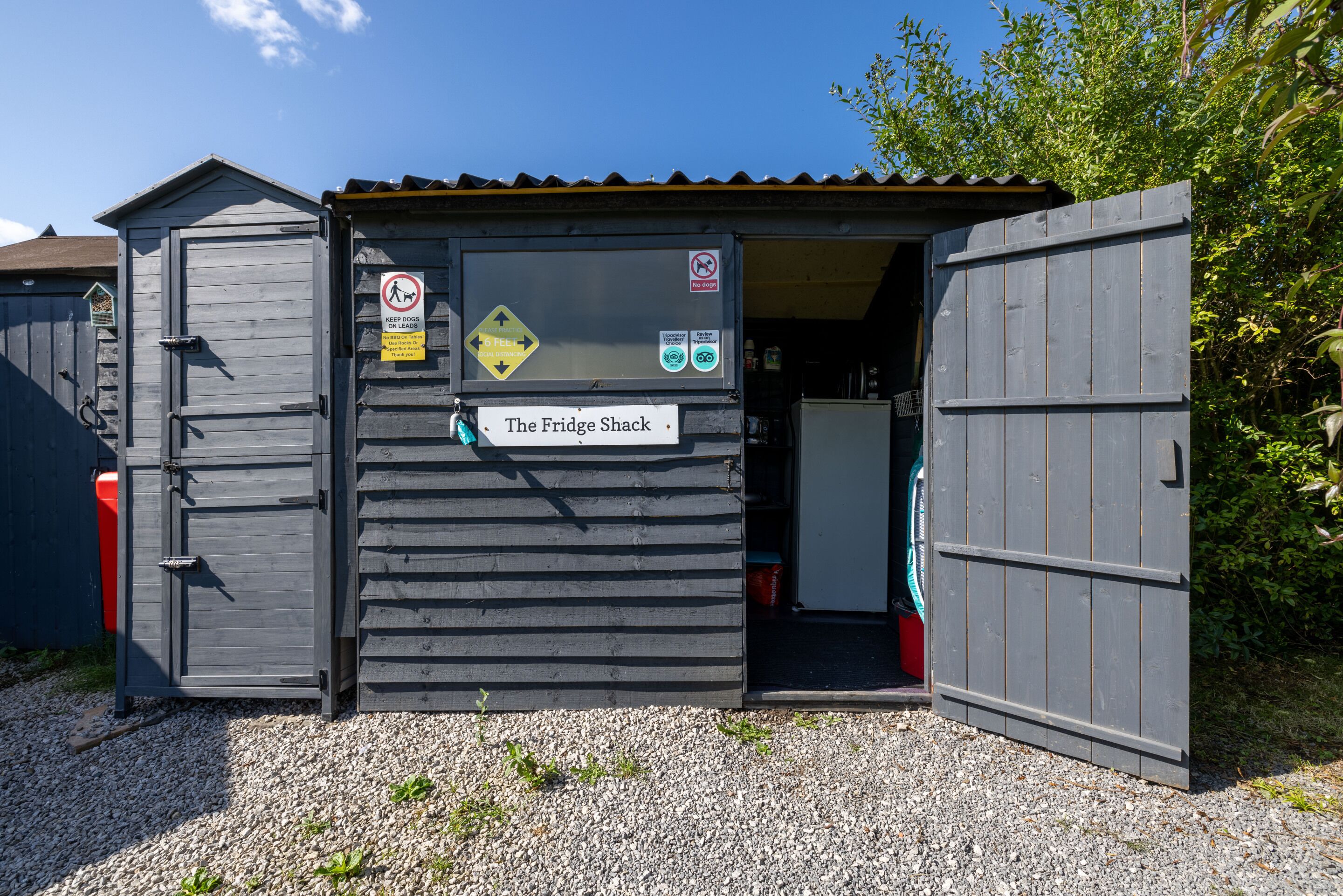 A small, wooden structure labeled "The Fridge Shack" with a sign indicating no dogs allowed.
