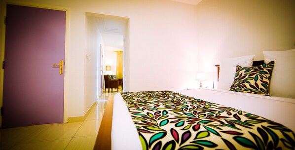 A hotel room with a bed, a desk, and a chair. - Hotel L'Adagio (Libreville)