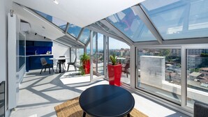 A modern apartment with a large skylight, a dining area, and a view of the city. - Juno Hotel Taksim (Istanbul)