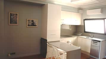 Una cocina moderna con armarios blancos, horno empotrado y ventana sobre el fregadero.