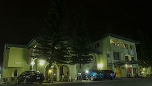 A two-story building with a sign reading "Muster Point" and a "No Parking" sign. There are two cars parked in front. - EEMJM Hotels and Suites Limited (Uyo)