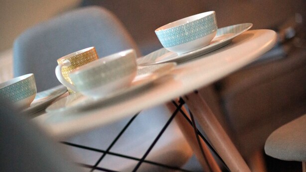 A dining area with a table and chairs, a bowl, and a cup on the table. - Kings Cross Apartments (London)