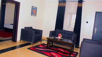 Suite Business, 1 letto king | Area soggiorno | TV a schermo piatto