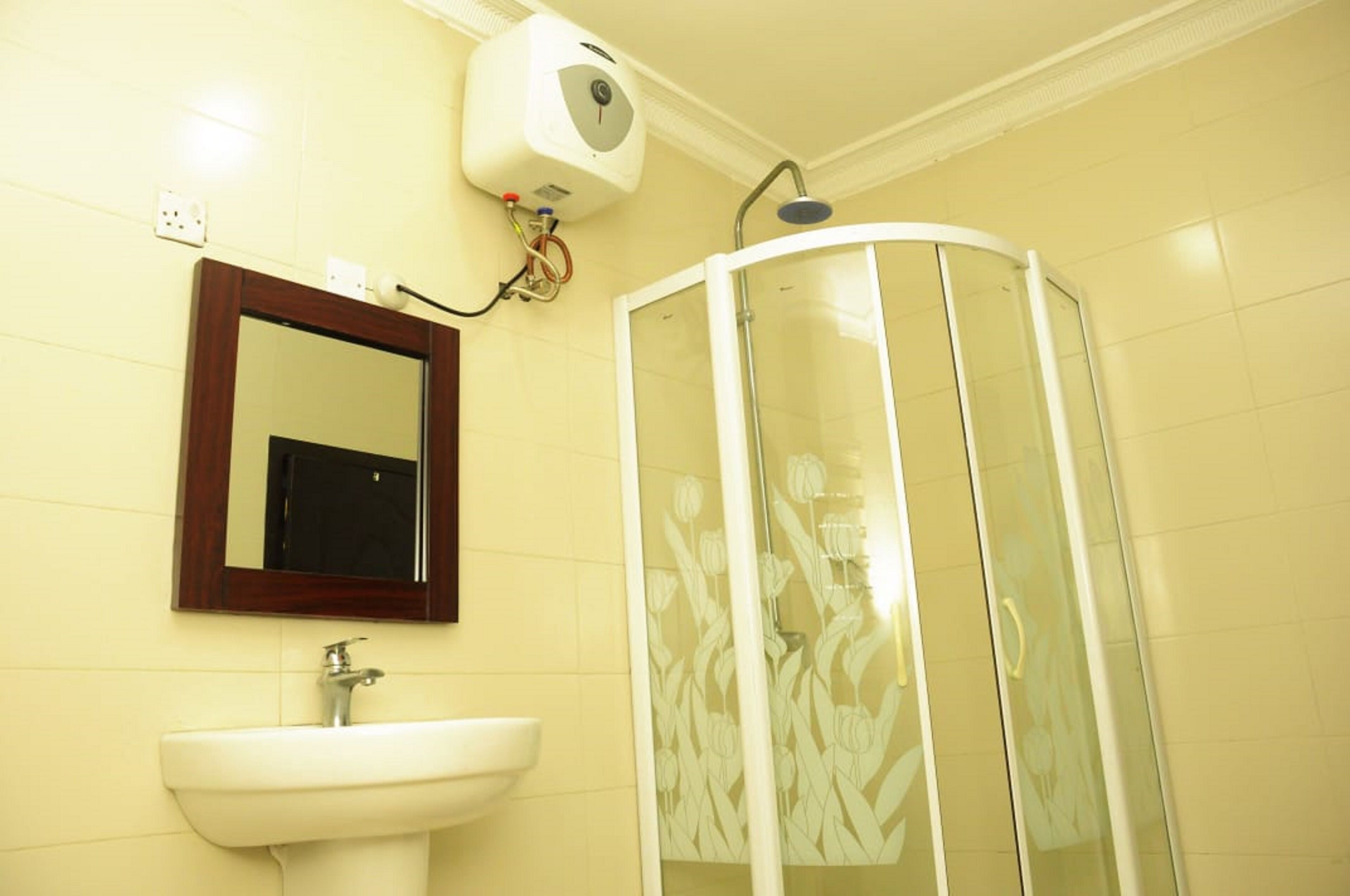 A bathroom with a white sink, a mirror, and a glass-enclosed shower.