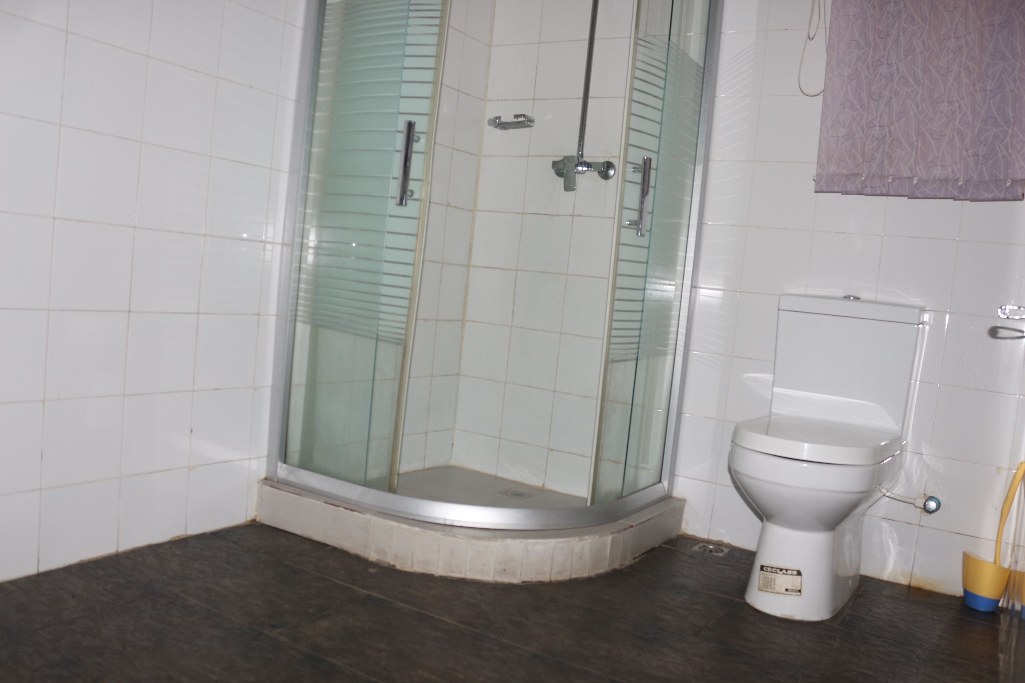 A bathroom with a glass-enclosed shower, a toilet, and a bathtub.
