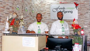 A reception desk with a sign reading "Fresh Spring" and decorative Christmas trees. - Fresh Spring Hotels & Towers (Uyo)