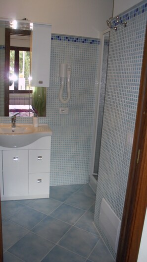 Habitación con 1 cama matrimonial o 2 individuales | Baño | Regadera, amenidades de baño gratuitas, secadora de cabello, batas 