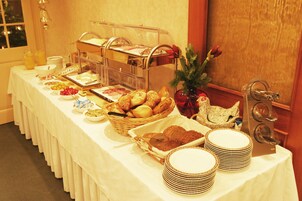 Una mesa de buffet con diversos alimentos y una estación de café.