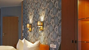 A hotel room with a bed, a desk, a chair, and a wardrobe. - Hotel Garni Haffmans (Grefrath)