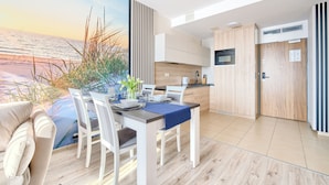 A modern kitchen with white cabinetry, a built-in oven, and a microwave. - Sun & Snow - Olympic Park (Kolobrzeg)