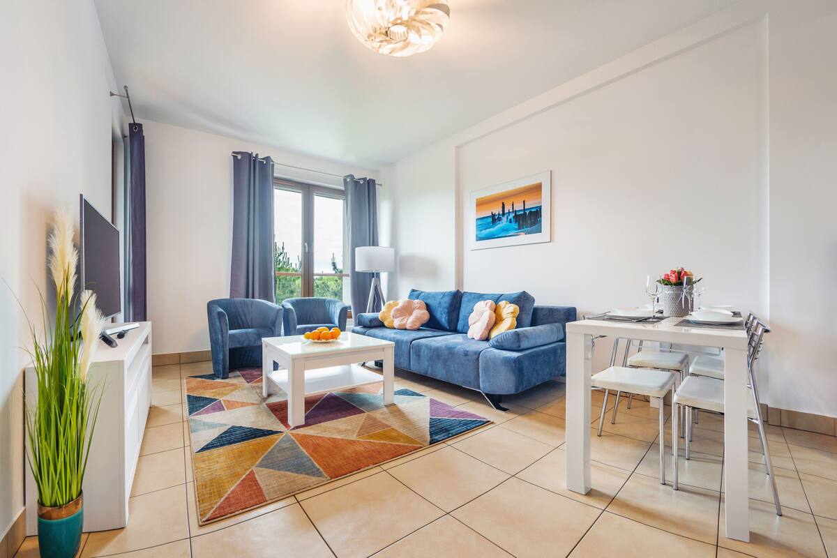 Ein modernes Wohnzimmer mit einer Couch, einem Couchtisch und einem Esstisch.