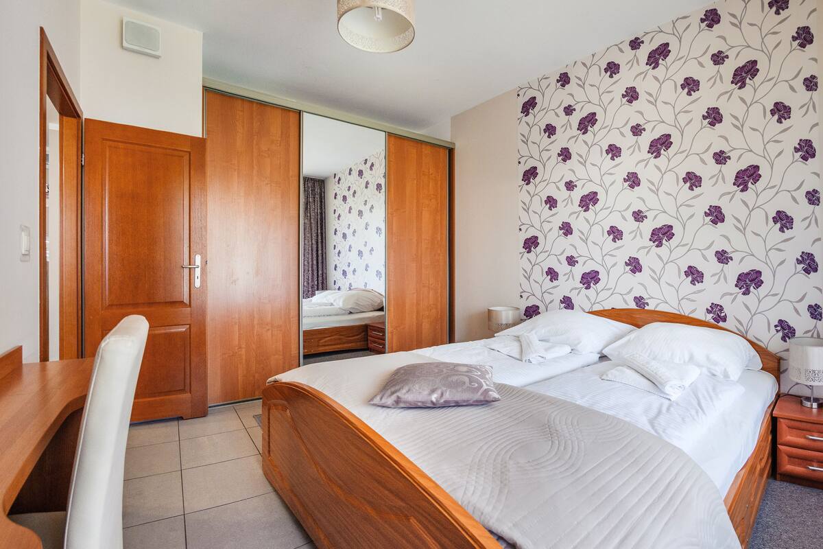 Ein Hotelzimmer mit einem hölzernen Bett, einem Schreibtisch und einem Spiegel.
