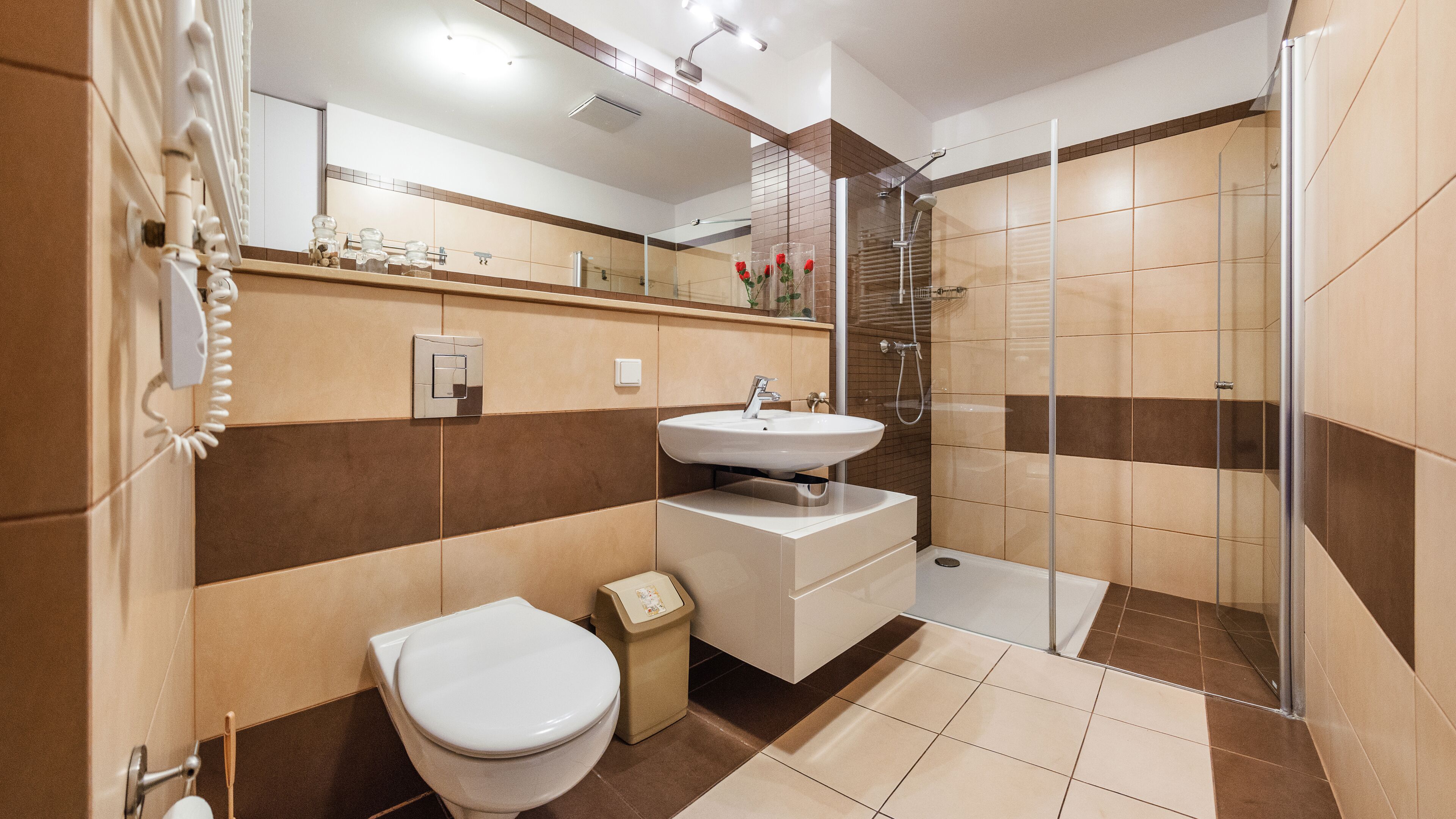 Un baño moderno con inodoro, lavamanos y ducha.